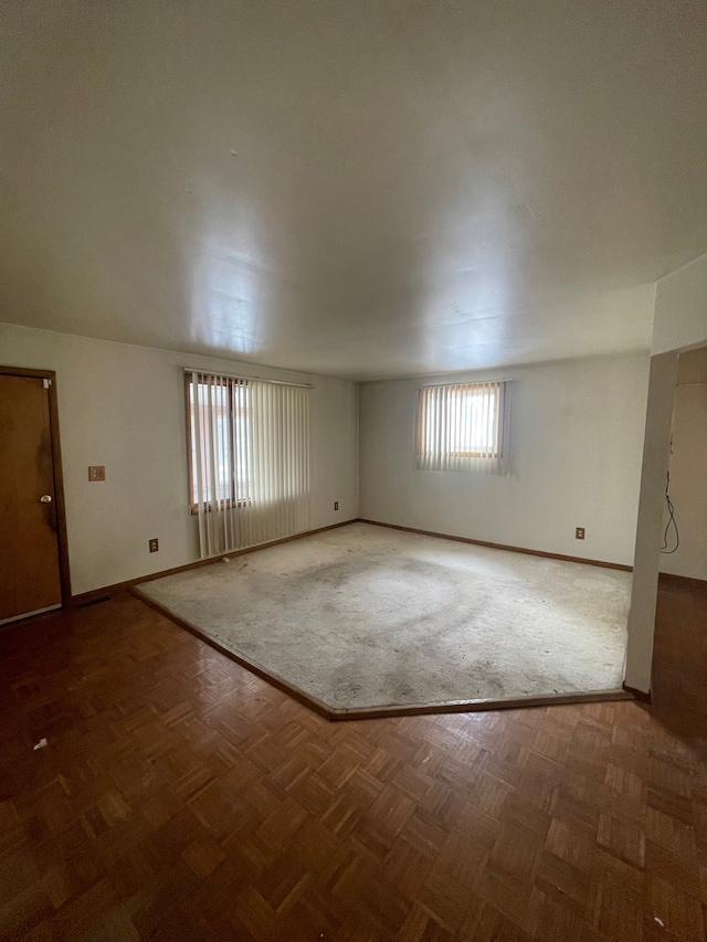 unfurnished room with baseboards