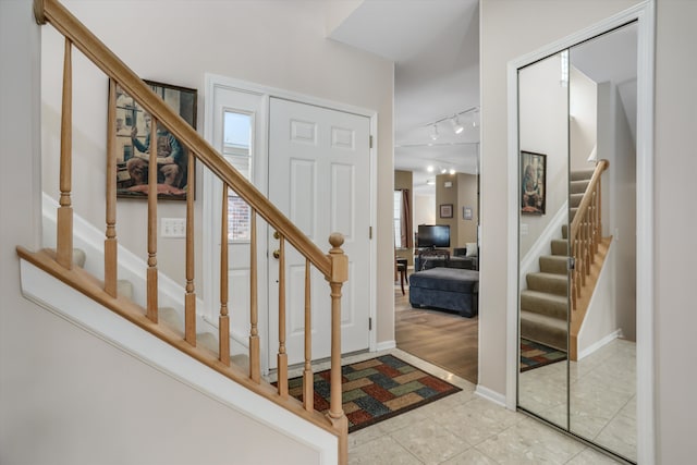 foyer featuring light tile patterned floors and track lighting