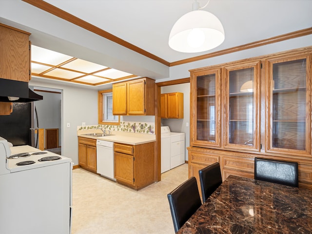 kitchen with sink, backsplash, ornamental molding, washing machine and clothes dryer, and white appliances