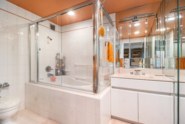 full bathroom with tile patterned flooring, enclosed tub / shower combo, vanity, and toilet