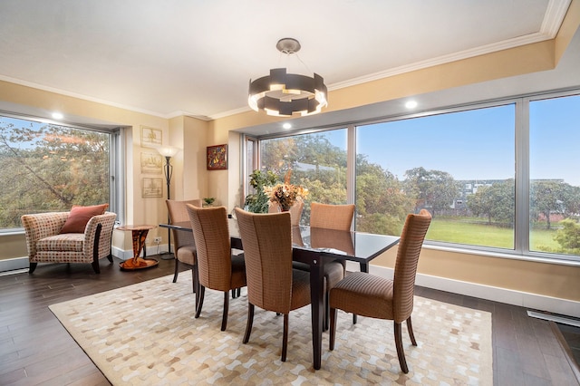 dining space with wood-type flooring, ornamental molding, and an inviting chandelier