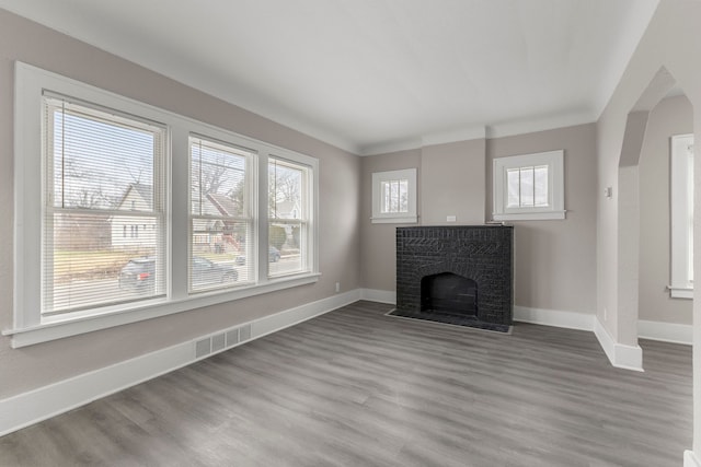 unfurnished living room with light hardwood / wood-style flooring, a fireplace, and ornamental molding