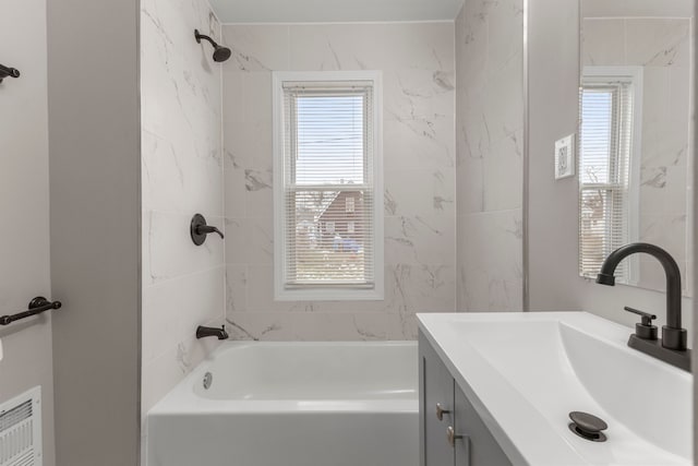 bathroom featuring tiled shower / bath combo and vanity