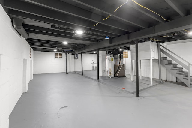 basement with sink, heating unit, and gas water heater