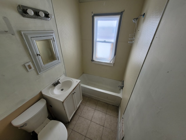 bathroom with tile patterned floors, toilet, vanity, and a washtub