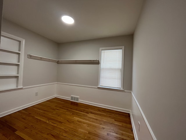 unfurnished room featuring hardwood / wood-style floors and built in features