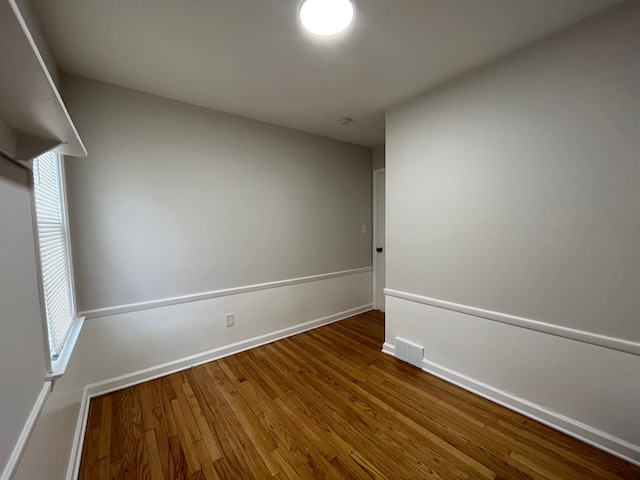 unfurnished room with visible vents, baseboards, and wood finished floors