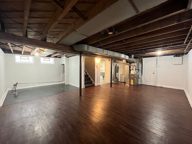 basement with gas water heater, dark hardwood / wood-style floors, and heating unit