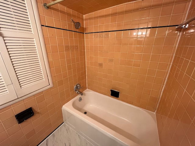 bathroom with shower / washtub combination and tile walls