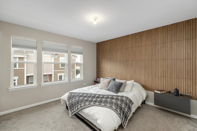 carpeted bedroom with wooden walls