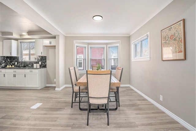 dining space featuring sink and light hardwood / wood-style floors