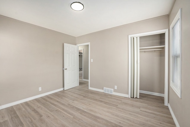 unfurnished bedroom with light hardwood / wood-style floors and a closet