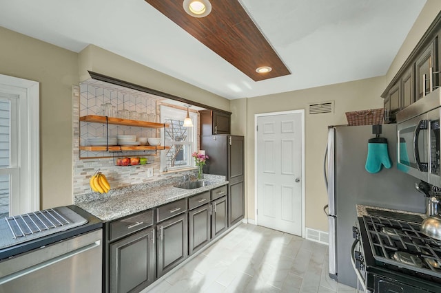 kitchen featuring dark brown cabinetry, stainless steel appliances, sink, and backsplash