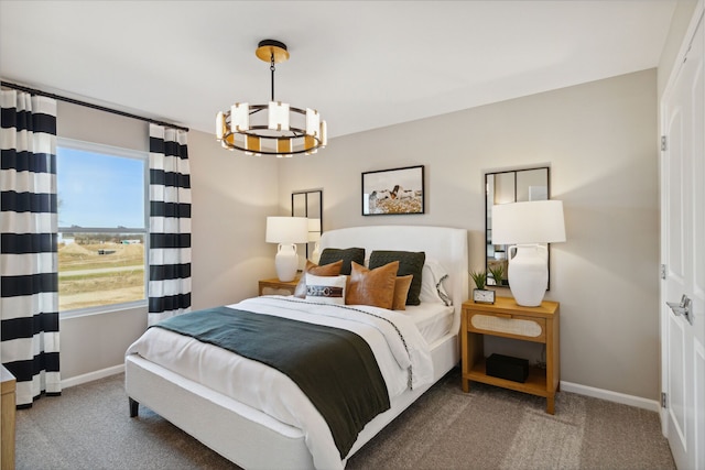 carpeted bedroom featuring a notable chandelier and baseboards