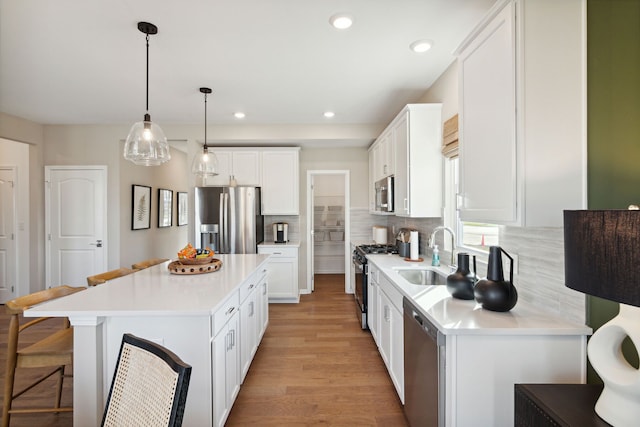 kitchen featuring tasteful backsplash, a center island, a breakfast bar, stainless steel appliances, and a sink