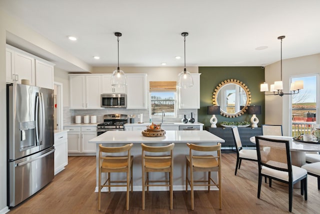 kitchen featuring a wealth of natural light, decorative backsplash, stainless steel appliances, and light countertops