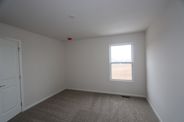 carpeted spare room with baseboards