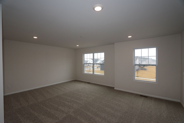 carpeted empty room with visible vents, recessed lighting, and baseboards