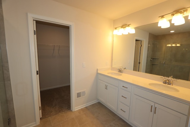 full bath with a sink, visible vents, a spacious closet, and a shower stall