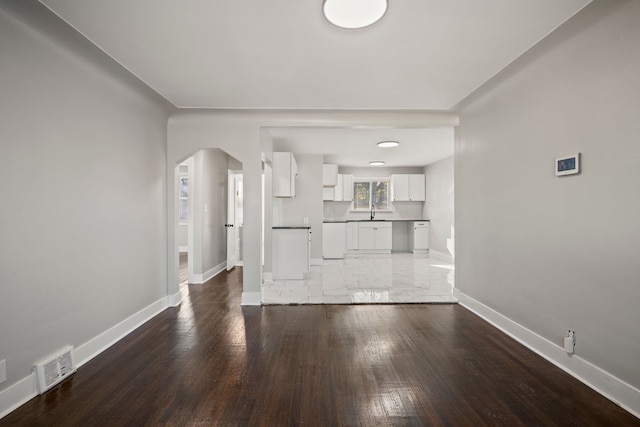 unfurnished living room featuring sink and dark hardwood / wood-style floors