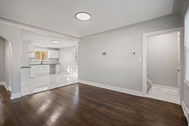 unfurnished living room featuring sink and dark hardwood / wood-style floors