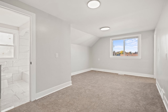 additional living space featuring lofted ceiling and carpet floors