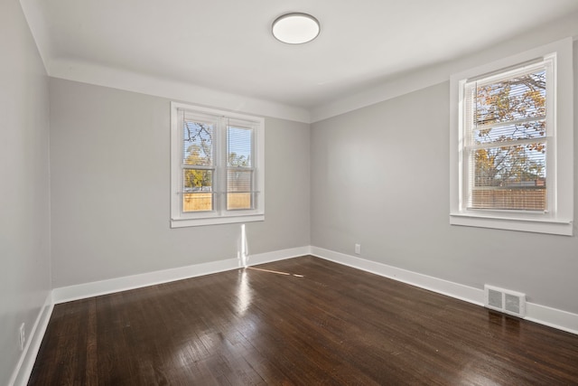 unfurnished room with plenty of natural light and dark hardwood / wood-style floors