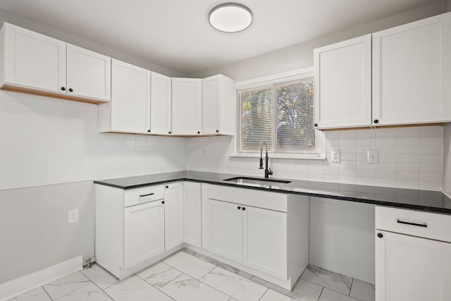 kitchen with white cabinetry, sink, and tasteful backsplash