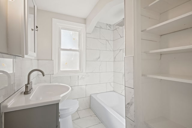 bathroom with vanity, tile walls, and toilet