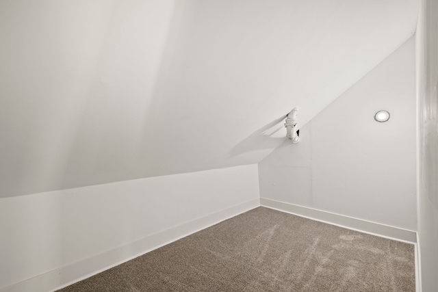 bonus room with lofted ceiling and carpet flooring