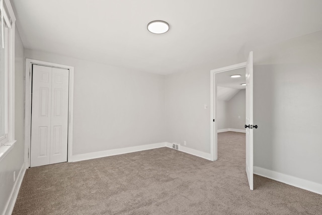 unfurnished bedroom featuring carpet floors and a closet