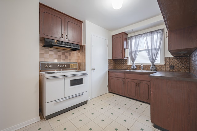 kitchen featuring range with two ovens, dark brown cabinets, sink, and backsplash