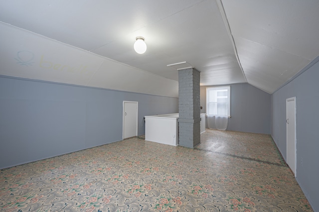 bonus room featuring lofted ceiling and ornate columns