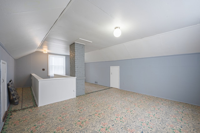 additional living space featuring decorative columns and lofted ceiling