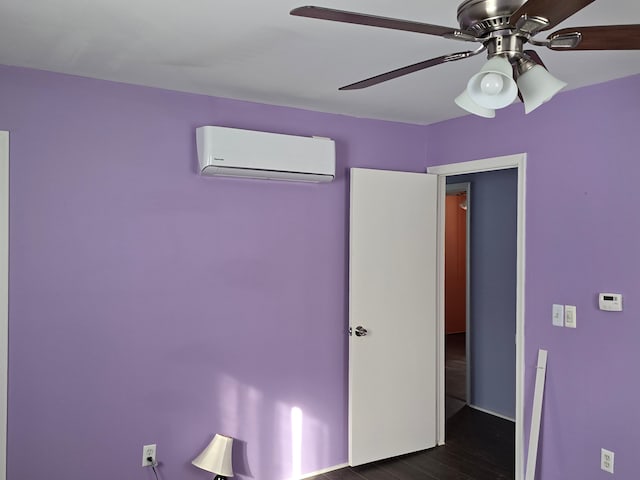 unfurnished bedroom featuring a wall mounted air conditioner, dark hardwood / wood-style floors, and ceiling fan