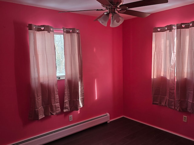 spare room featuring dark hardwood / wood-style flooring, a baseboard heating unit, and ceiling fan