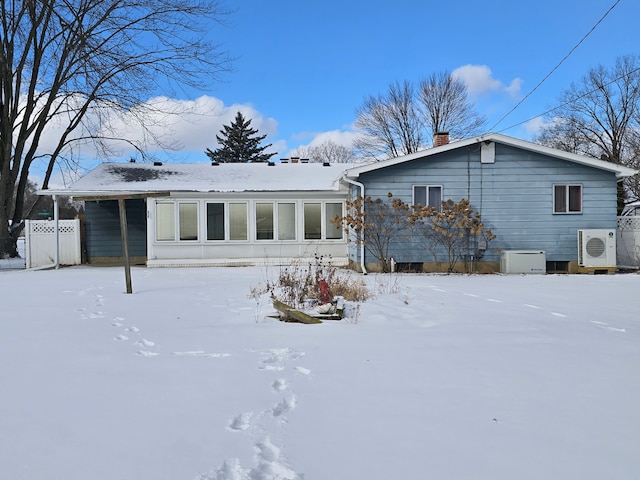 snow covered rear of property with ac unit