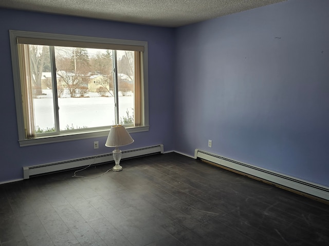 empty room with baseboard heating and a textured ceiling