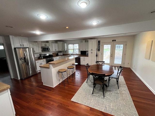 11954 Portage Lake Ave, Pinckney, MI 48169 - dining area featuring dark wood finished floors, a wealth of natural light, baseboards, and french doors