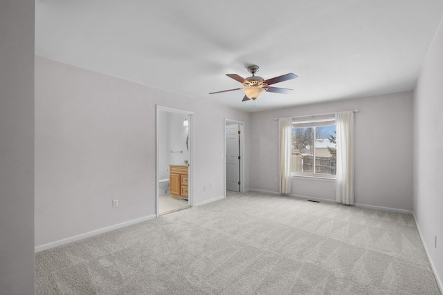 unfurnished bedroom with light carpet, connected bathroom, and ceiling fan