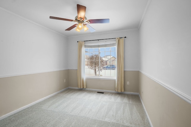 spare room featuring crown molding, ceiling fan, and carpet