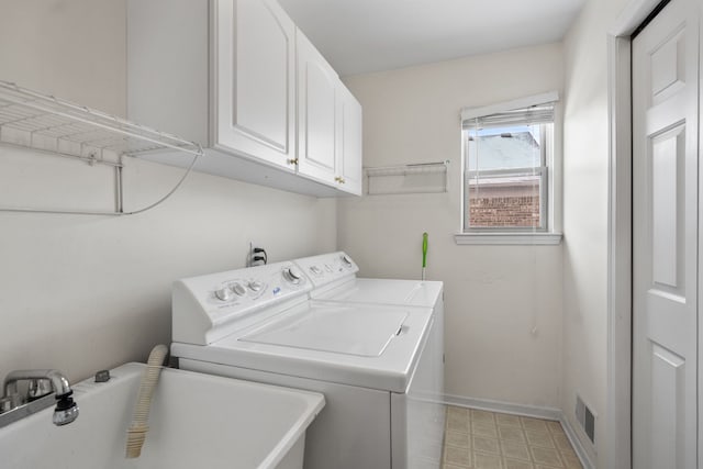 clothes washing area with cabinets, washing machine and clothes dryer, and sink