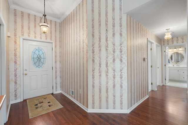 foyer entrance featuring dark wood-type flooring and ornamental molding