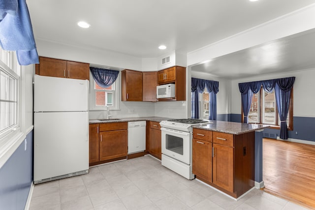 kitchen featuring sink, light stone counters, white appliances, and kitchen peninsula