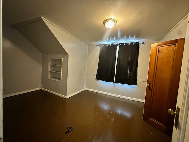 additional living space with dark wood-type flooring and built in shelves