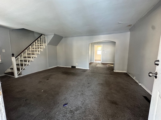 unfurnished living room featuring dark colored carpet