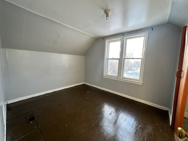 bonus room featuring vaulted ceiling and dark hardwood / wood-style flooring