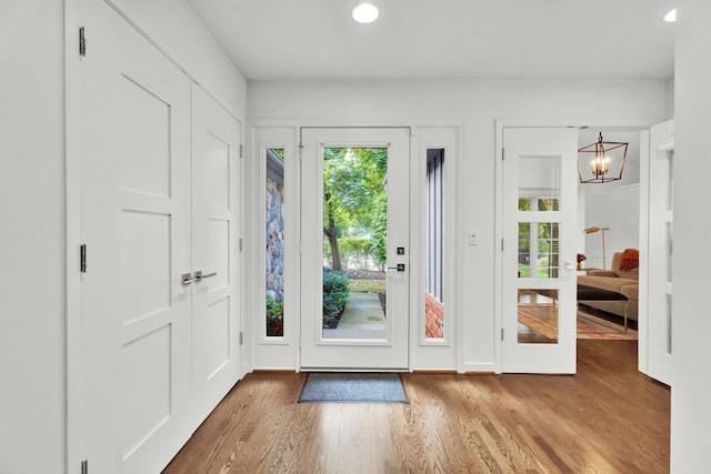 doorway featuring a chandelier and light wood-type flooring