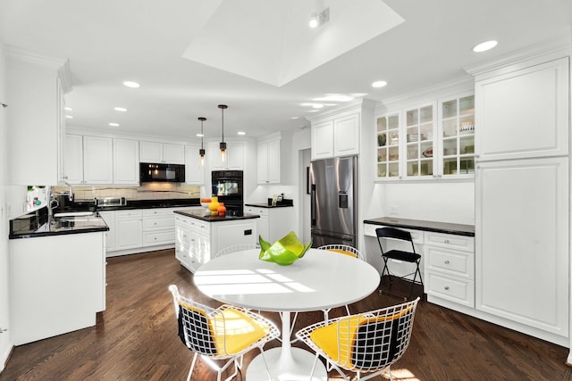 kitchen featuring white cabinetry, a center island, pendant lighting, and black appliances