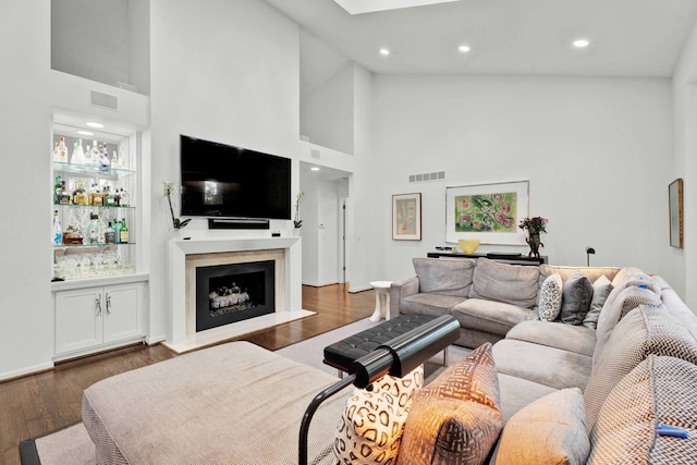 living room with dark hardwood / wood-style flooring and a towering ceiling